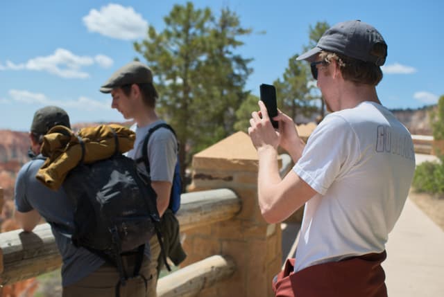 Picture of Jesse taking a picture of Sam taking a picture of Peter holding a butterfly
